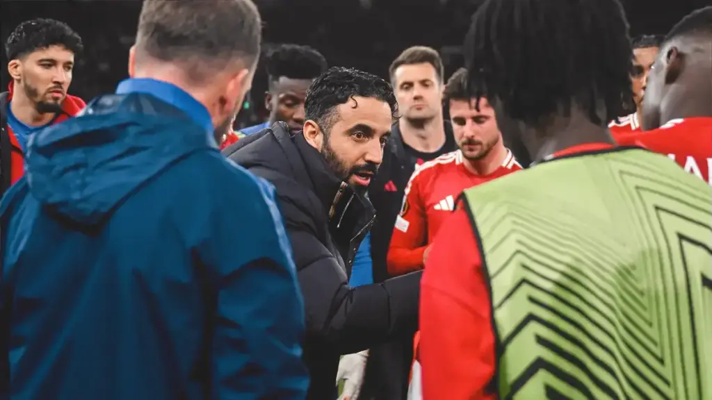 Ruben Amorim addressing Manchester United players in a huddle.