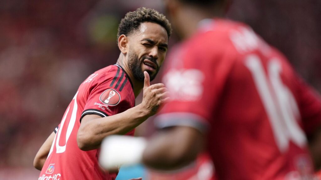 Matheus Cunha wearing Manchester United kit giving a thumbs up gesture.